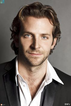 a close up of a person wearing a suit and tie with a smile on his face