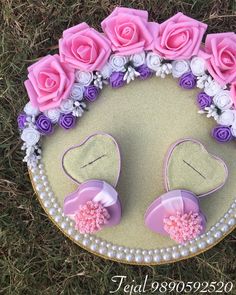 a cake decorated with flowers and pearls on top of a tablecloth covered in grass