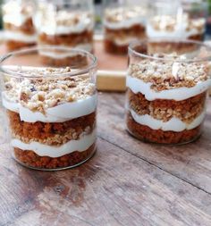 several desserts in small glass containers on a wooden table