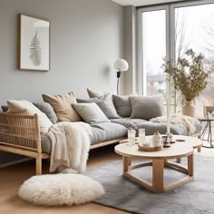 a living room filled with furniture next to a large glass window and lots of windows