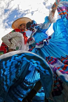 two people dressed in colorful clothing and hats