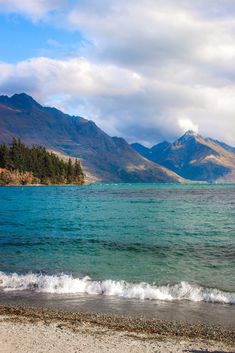 an ocean with mountains in the background