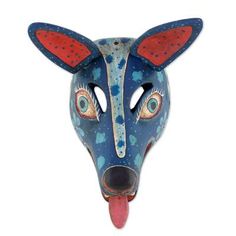 an animal mask with blue and red paint on it's face, showing its tongue