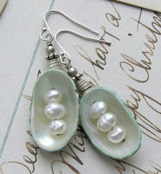 two peas with pearls are hanging from earrings