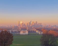 the city skyline as seen from greenwich common park in london, england at sunset or dawn