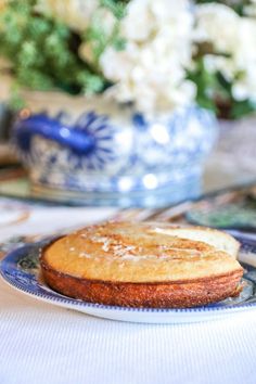 a piece of cake sitting on top of a blue and white plate next to flowers