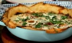 a casserole dish with cheese and spinach in it on a wooden table