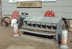 an old metal bench sitting in front of a building with red and white polka dots on it