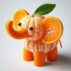 an elephant made out of oranges with a leaf on its head