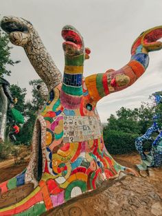 a colorfully painted elephant statue sitting on top of a dirt field