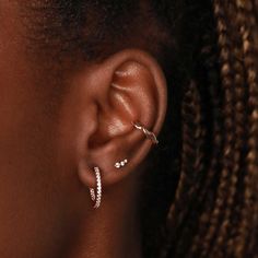 a close up of a woman's ear with two diamond hoops on it