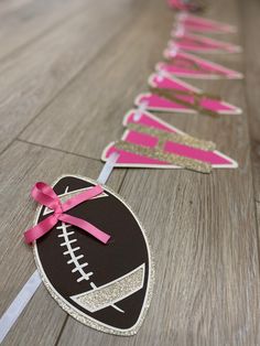 pink and black paper streamers with footballs on them, tied to the floor