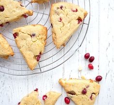 several pieces of cherry scones on a wire rack next to some cranberries