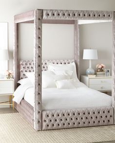 a bedroom with a four poster bed and white linens on the pillows, along with two nightstands