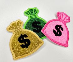 three different colored bags with dollar signs on them