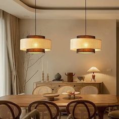 a dining room table and chairs with lights hanging from the ceiling above it, along with two lamps on either side of the table