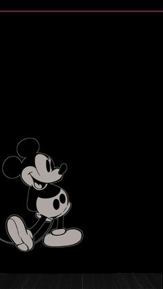 a black and white mickey mouse wallpaper in a room with wood flooring at night