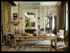 a table with fruit on it in front of a mirror and window curtained walls