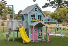 a play house with a slide in the grass