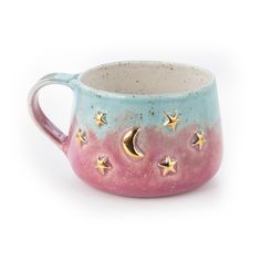 a ceramic mug with stars and moon designs on it's side, sitting against a white background