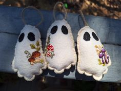 three stuffed animals are hanging on a wooden bench with some string attached to the back