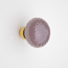 a purple glass door knob on a white surface with a yellow top and black bottom