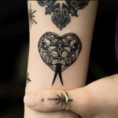 a woman's arm with a tattoo on it and a heart shaped knife in the middle