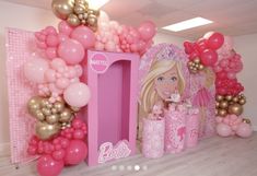 a barbie birthday party with pink and gold balloons on the wall, princess castle in the center