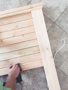 a person sanding up some wood on the ground