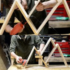 two men working on wooden structures in a workshop with one man holding an electric drill