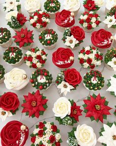 cupcakes decorated with red and white flowers are on display