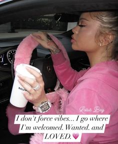 a woman in pink driving a car holding a coffee cup with the caption i don't force vibes i go where i'm welcomed wanted and loved