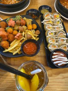 a table topped with plates of food and bowls of dipping sauces on top of it