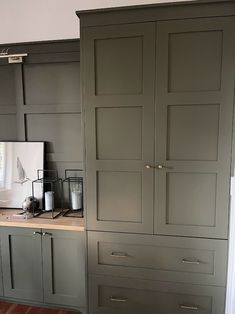 a kitchen with gray cabinets and wood floors