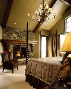 a bedroom with a bed, chair and fireplace in it