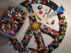 a peace sign made out of toys and other items on a table next to a plastic container