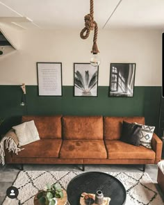 a living room filled with furniture and pictures hanging on the wall over a coffee table