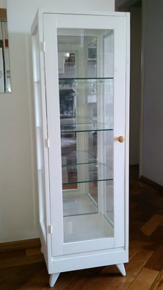 a white cabinet with glass doors and shelves