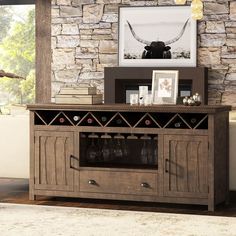 a living room with a stone wall and a wooden cabinet in front of the couch