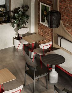 an empty restaurant with tables and chairs around them, in front of a brick wall