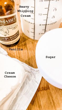 ingredients to make vanilla ice cream sitting on a wooden table next to a measuring cup