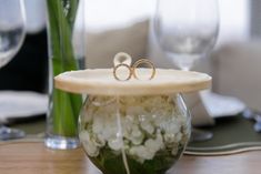 two wedding rings on top of each other in a vase filled with water and flowers