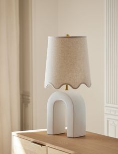 an elephant shaped lamp sitting on top of a wooden table next to a white dresser