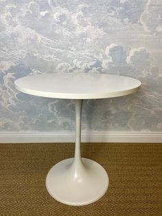 a white table sitting on top of a carpeted floor