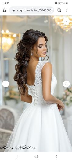 a beautiful woman in a white wedding dress looking back at the camera with her hand on her hip