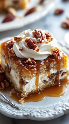 a piece of cake on a plate with caramel sauce and pecans around it