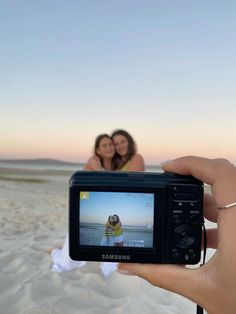 two women taking a photo on the beach