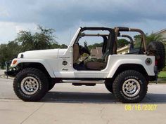 a white jeep is parked on the street