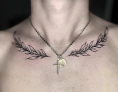 a man's chest with a cross and leaf tattoo on it