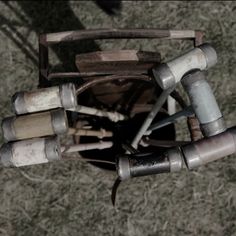 an overhead view of several different tools in a bucket on the ground with grass behind it